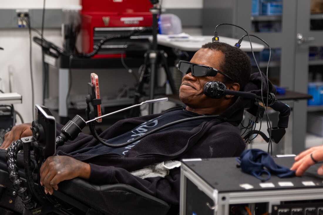 Person using an assistive brain-computer interface setup in a clinical environment