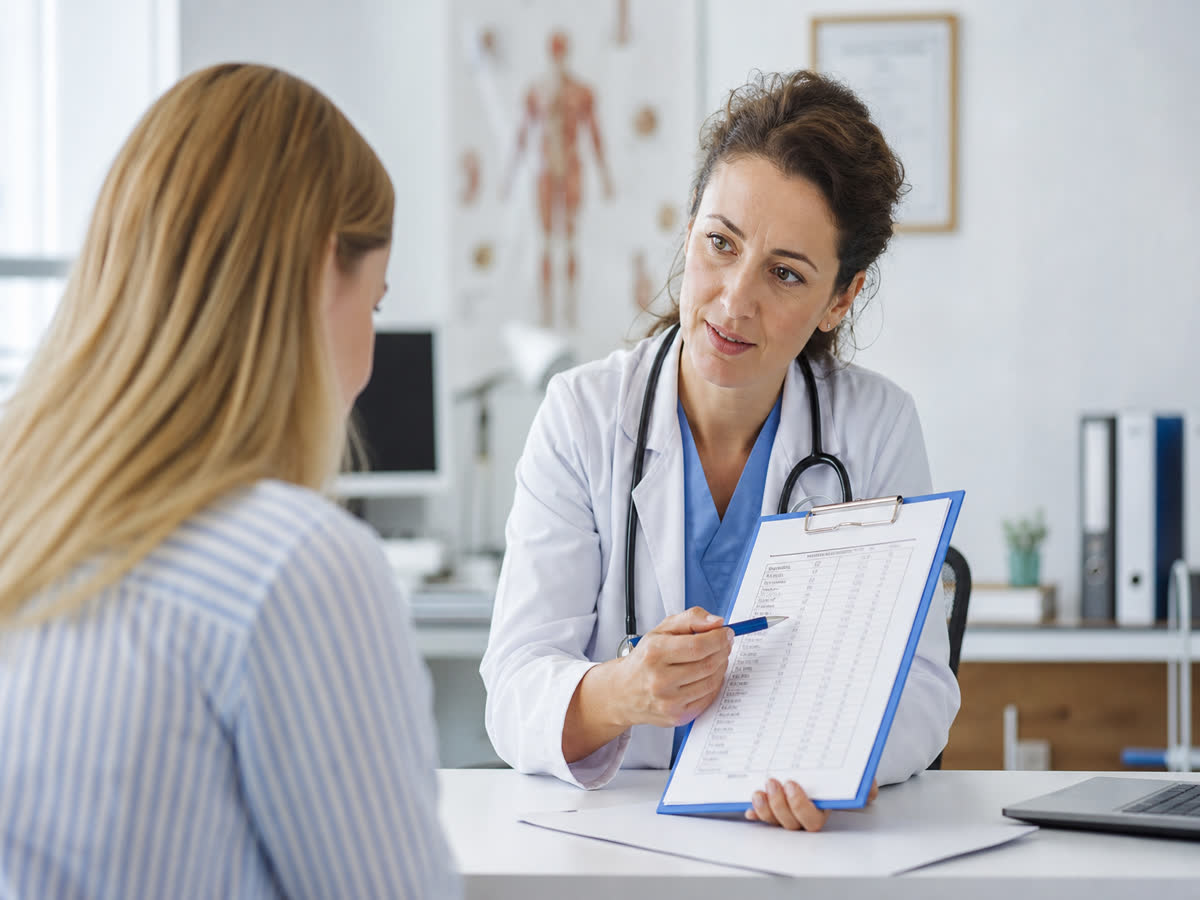 Doctor reviewing blood test results with a patient in a bright clinic